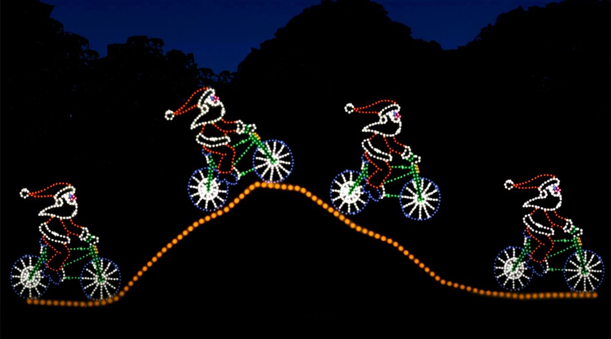 A multicolored lights display of four Santas riding bicycles at The Wonderland of Lights at the Dutchess County Fairgrounds in Rhinebeck